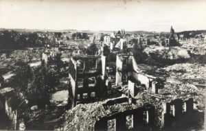 Blick auf eine zerstörte Stadt mit Ruinen und Trümmern.