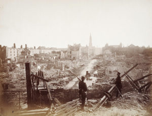 Zwei Soldaten schauen sich eine Trümmerlandschaft an.
