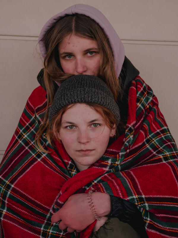 Menschen auf der Flucht aus der Ukraine: zwei Frauen, eingehüllt in eine Decke