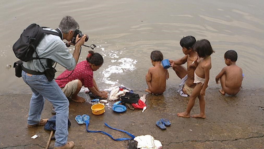 Ein Fotograf macht ein Foto von einer Familie an einem Gewässer in Indonesien