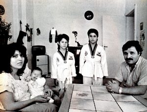 Foto einer 5-köpfigen Familie um einen Tisch versammelt