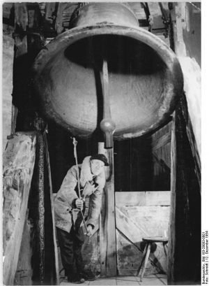 Ein Bild eines Mannes, der eine große Glocke zum Läuten bringt.