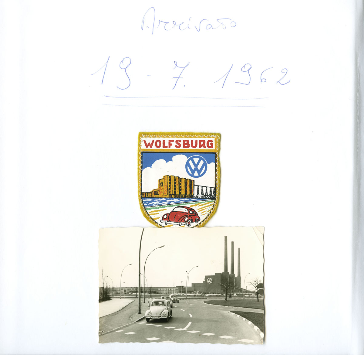 Seite eines Fotoalbums: Oben das Datum, 19.7.1962, darunter ein Wappen von Wolfsburg mit VW-Fabrik, Logo und Auto; darunter das Foto eines VWs auf einer Straße