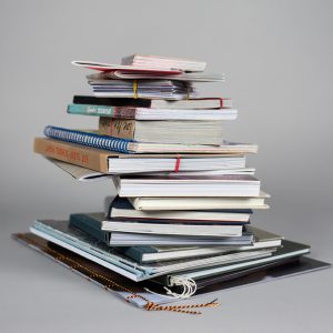 Ein Stapel von Büchern und Notizblöcken.