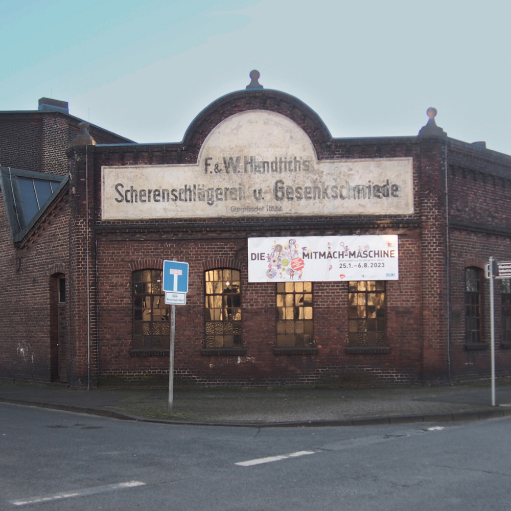 Eckfassade aus rotem Backstein mit der Aufschrift F. & W. Hendrichs Scherenschlägerei u. Gesenkschmiede, gegründet 1886