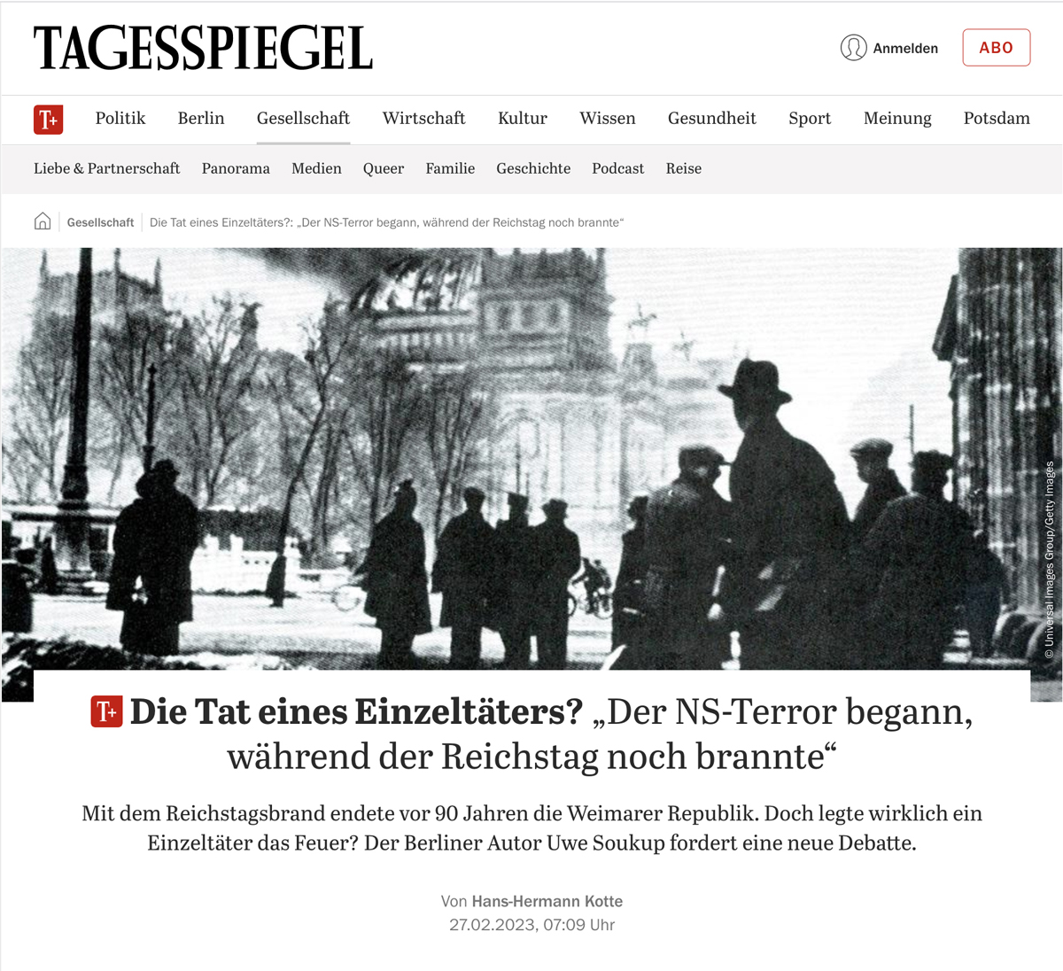 Screenshot der Website des „Tagesspiegel“ mit einem Schwarz-Weiß-Foto vom Berliner Reichstag: Mehrere Menschen stehen alleine und in Gruppen auf der Straße und blicken auf ein Gebäude, aus dessen Kuppel Qualm aufsteigt, auch Flammen sind zu erkennen.