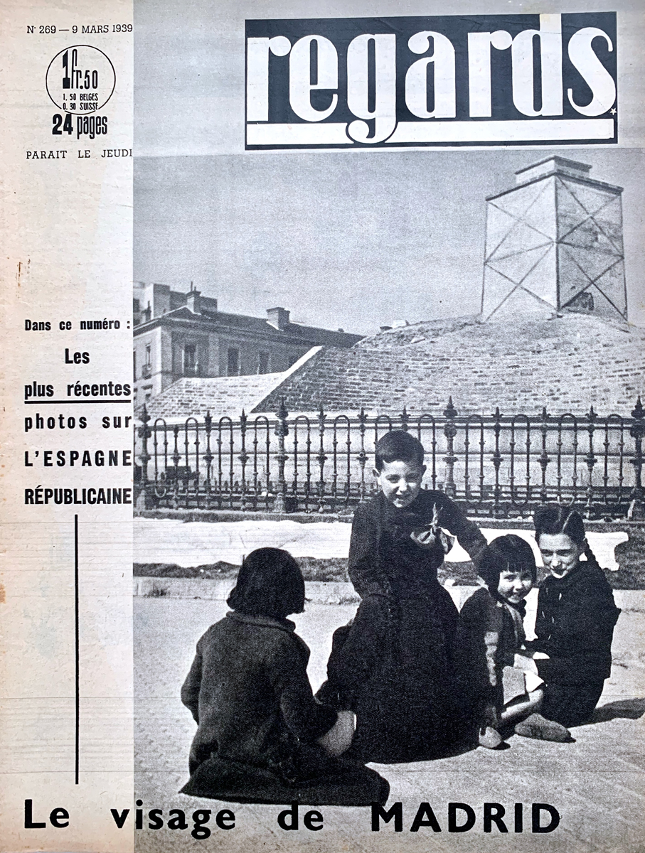 Cover eines Zeitschriftenhefts mit dem Bild von mehreren Kindern, die auf der Straße spielen; in Hintergrund ein Denkmal.