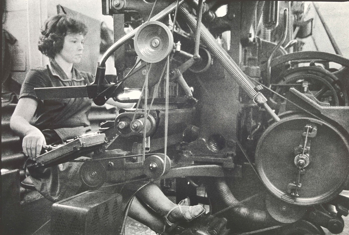 Frau sitzt an einer Linotype-Maschine