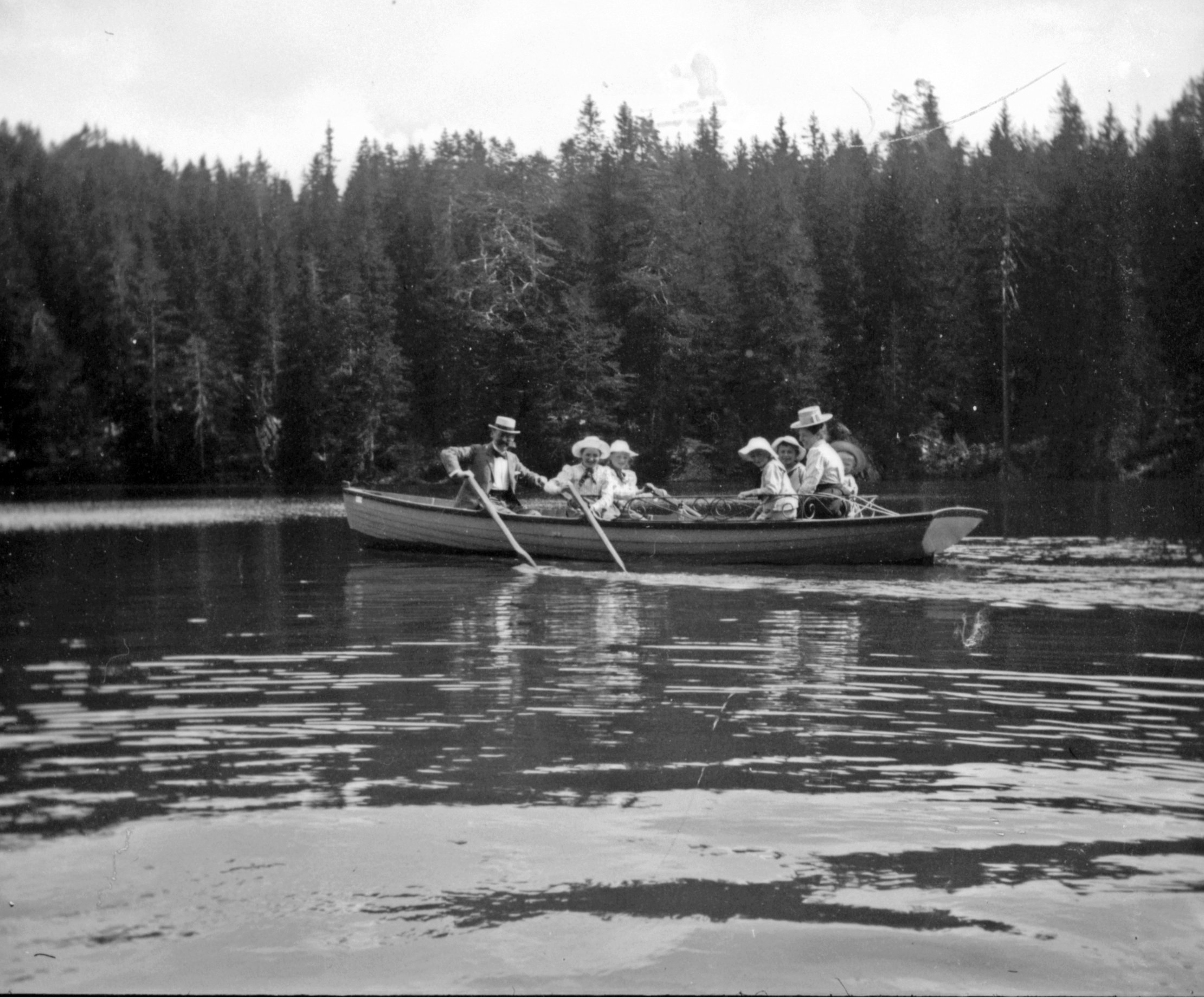 Familie rudert auf einem Boot am See