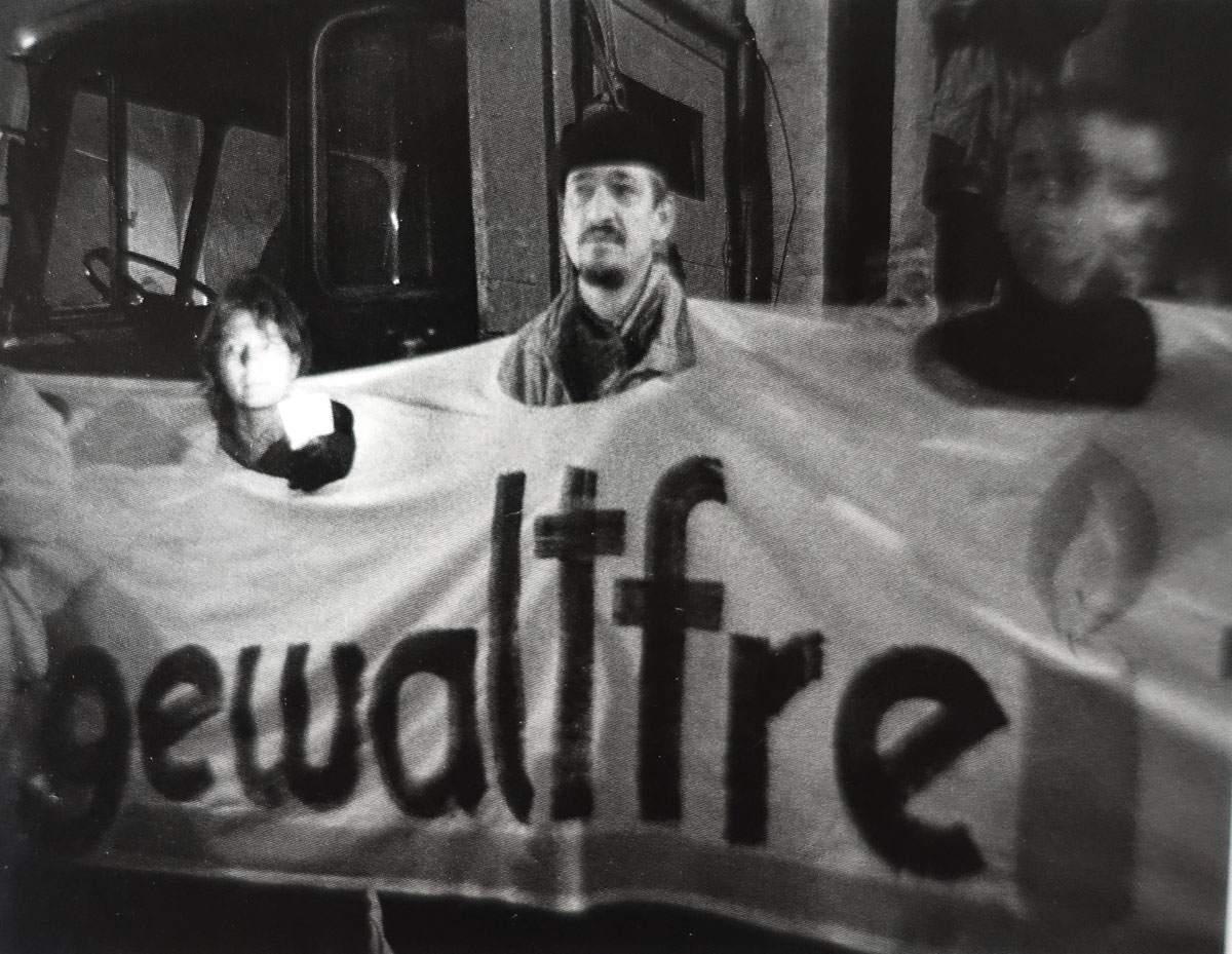 Schwarzweißfoto von demonstrierenden Menschen mit einem Banner