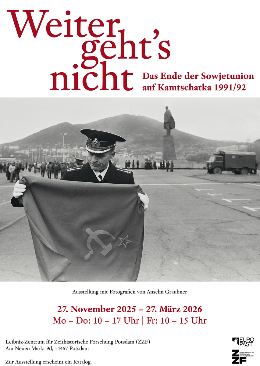 Ein Mann in Uniform legt auf einem Platz die Fahne der Sowjetunion zusammen.