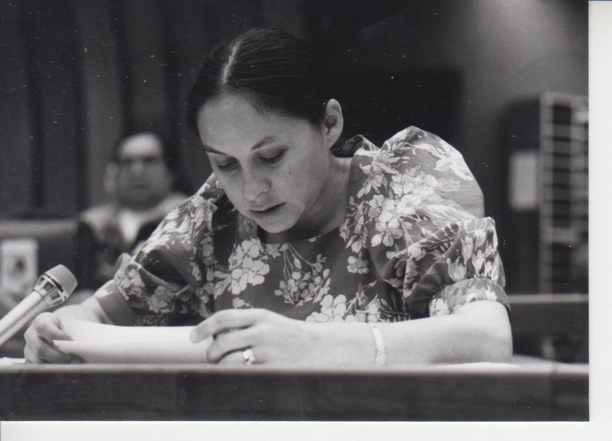 Schwarzweißfoto einer Frau, die ein Papier liest.