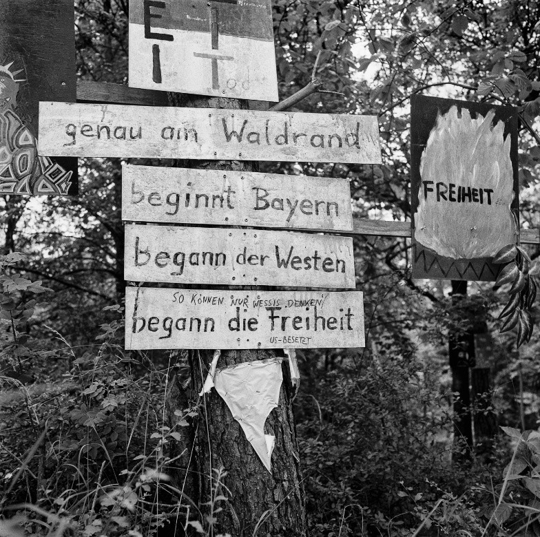 Schwarzweißfotografie von Holzschildern im Wald