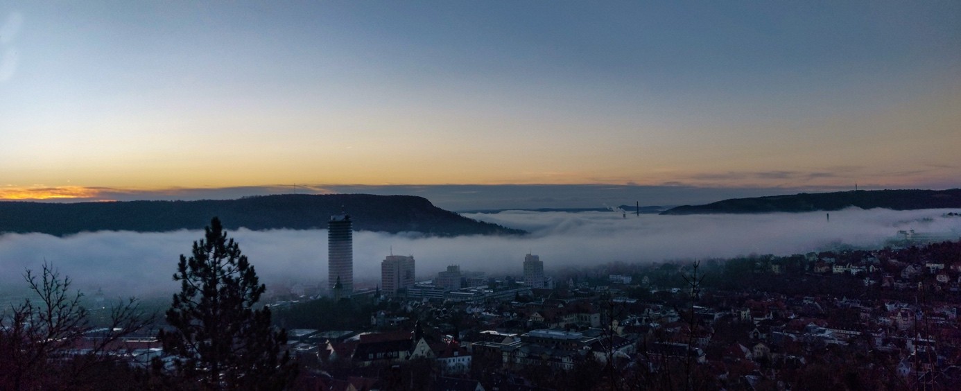 Farbfoto einer Stadtansicht mit Wolken von oben