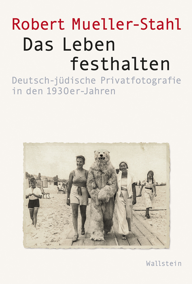 Grauer Buchumschlag mit roter und schwarzer Schrift und einem Foto von zwei Frauen mit einem Eisbären am Strand