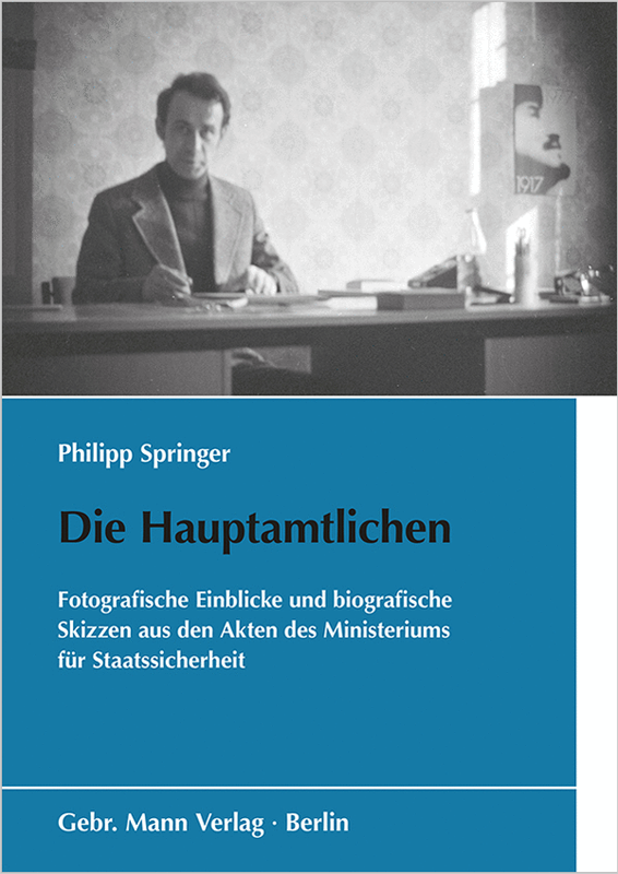 Cover Springer_Die Hauptamtlichen Buchcover mit Schwarzweißfoto eines Mannes am Schreibtisch, blauer Grund und Schrift