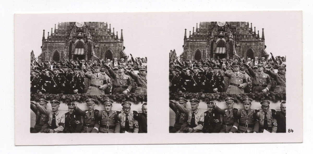Zwei schwarzweiße Stereoskop-Fotos von Männern in Uniform mit erhobenen Armen vor einem Gebäude