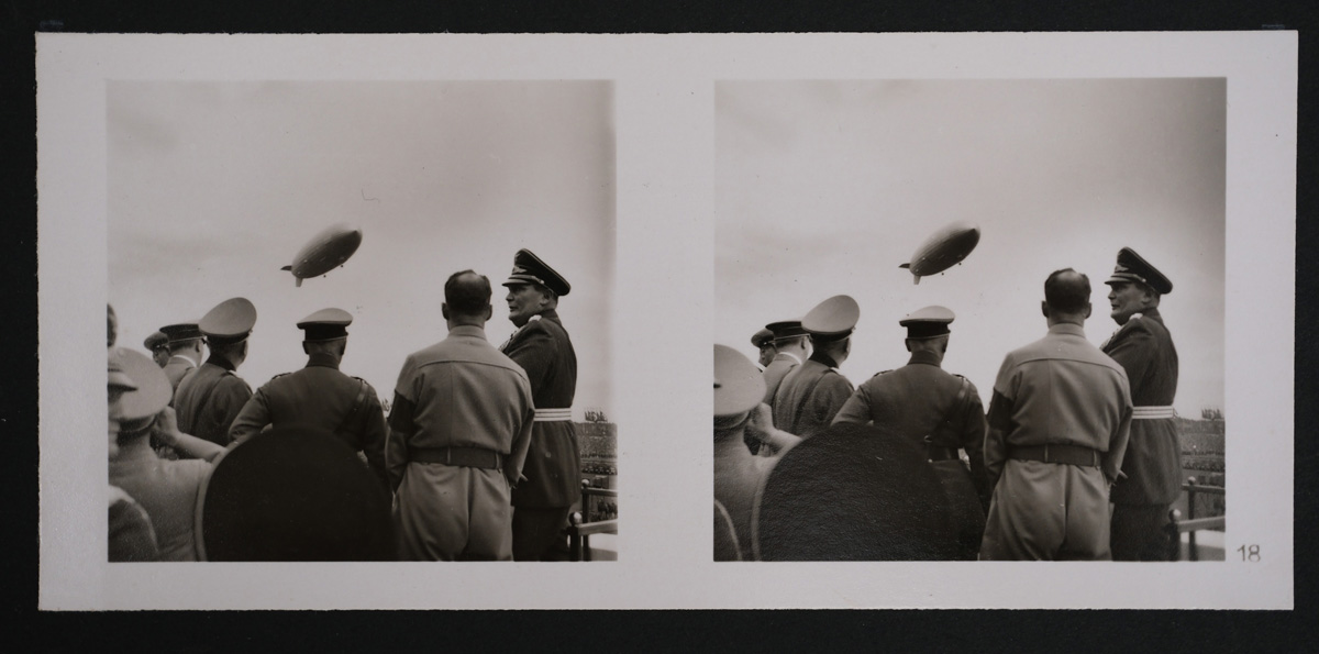 Zwei schwarzweiße Stereoskop-Fotos von Männnern in Uniform von hinten, über ihnen ein Zeppelin in der Luft